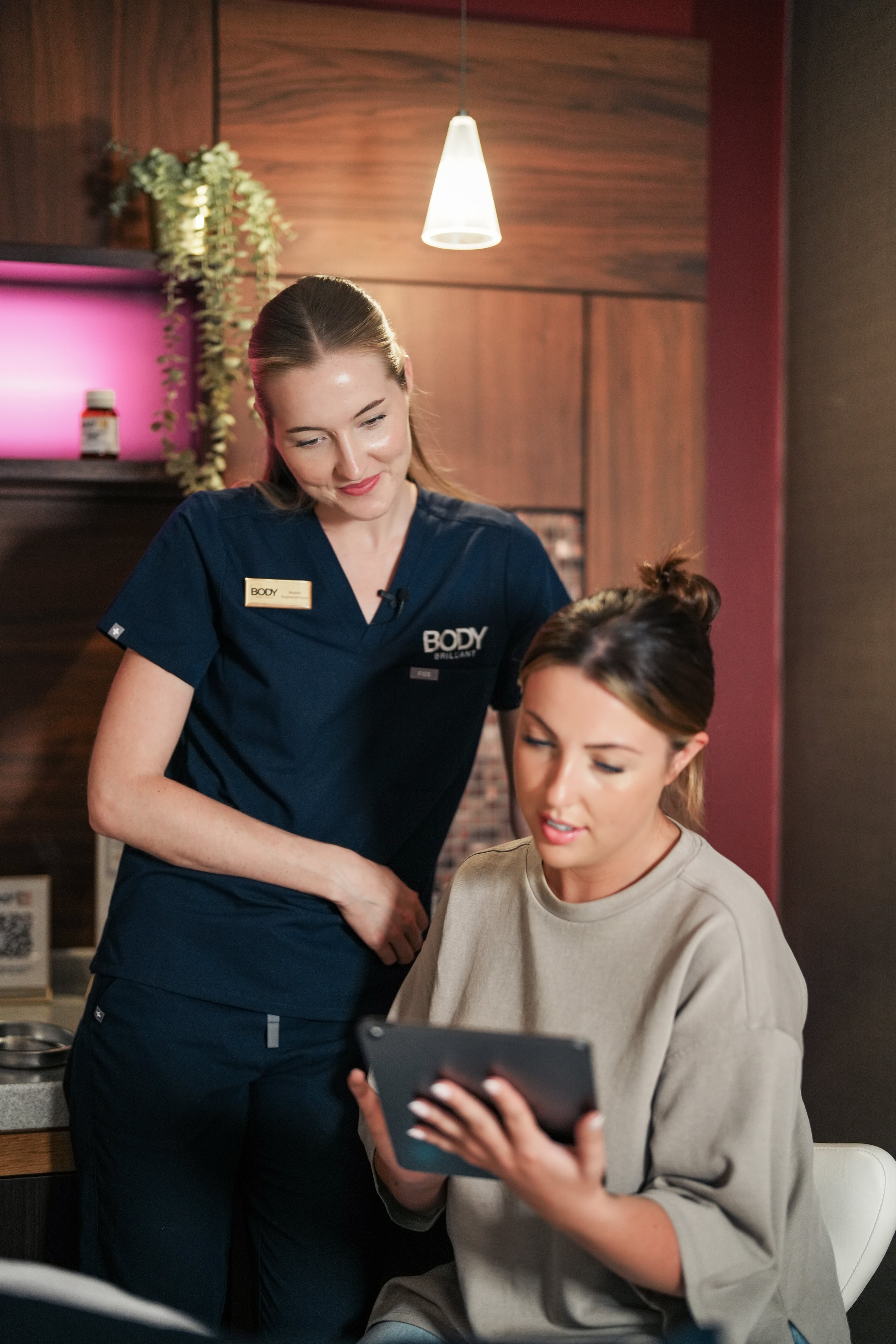 A Body Brilliant practitioner walking through the treatment menu on an iPad